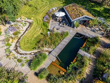 Aerial view of a house with green roof and swimming pond