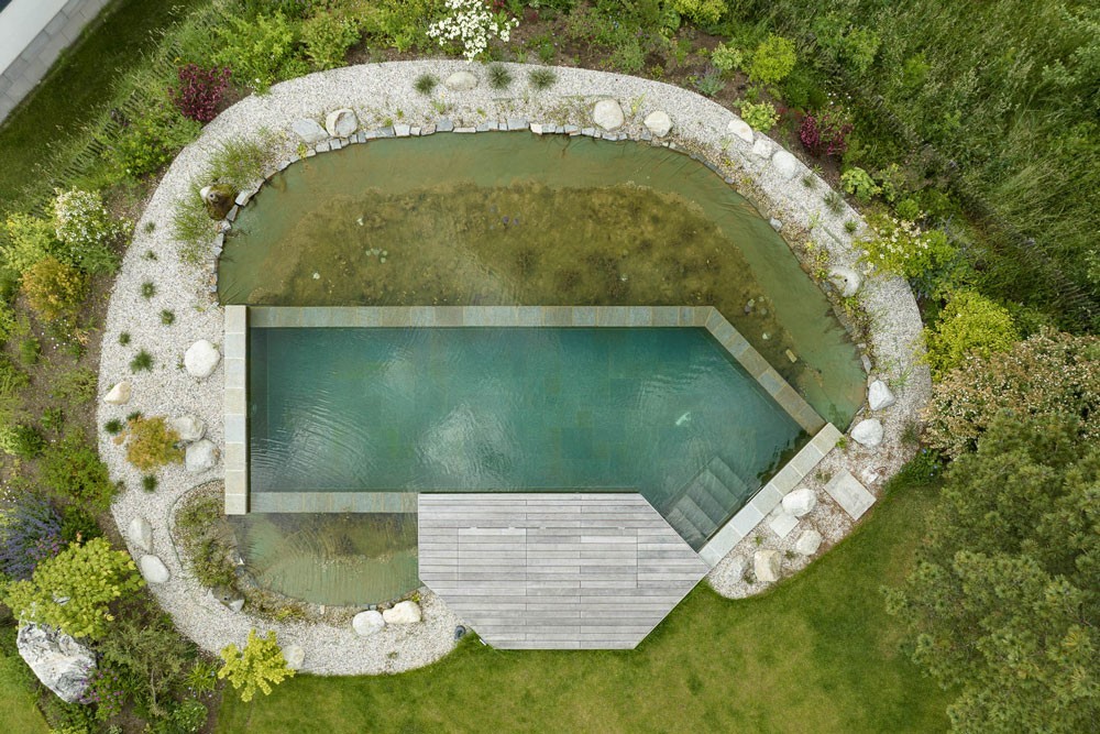 Aerial view of a swimming pond by Biotop with wooden terrace