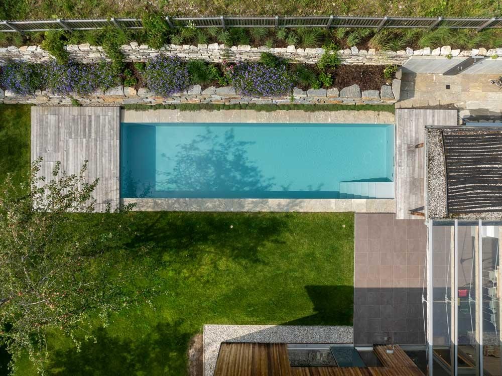 Biopool from above with terrace, lawn and natural stone wall