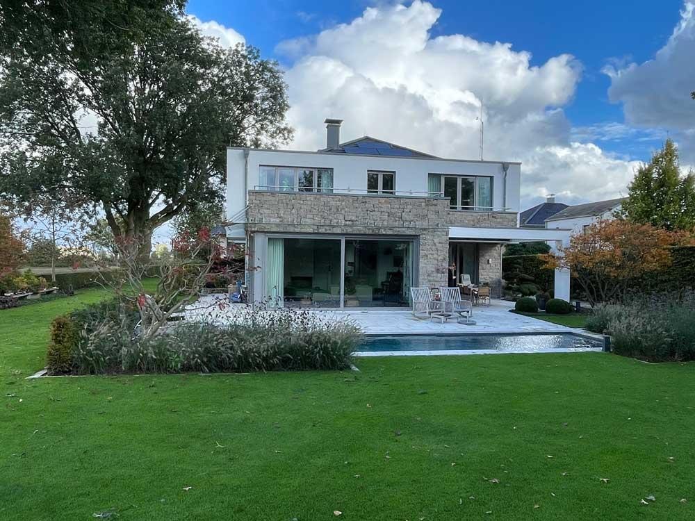 Biopool in front of a modern villa with terrace and landscaped garden