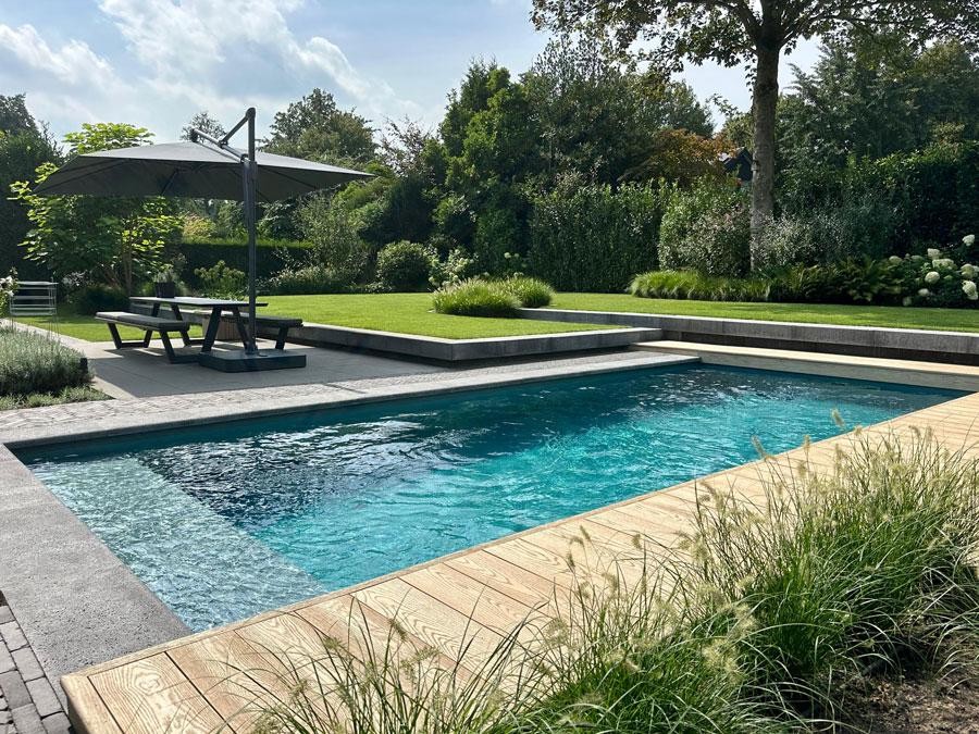 Designer pool with parasol and terrace in a modern garden