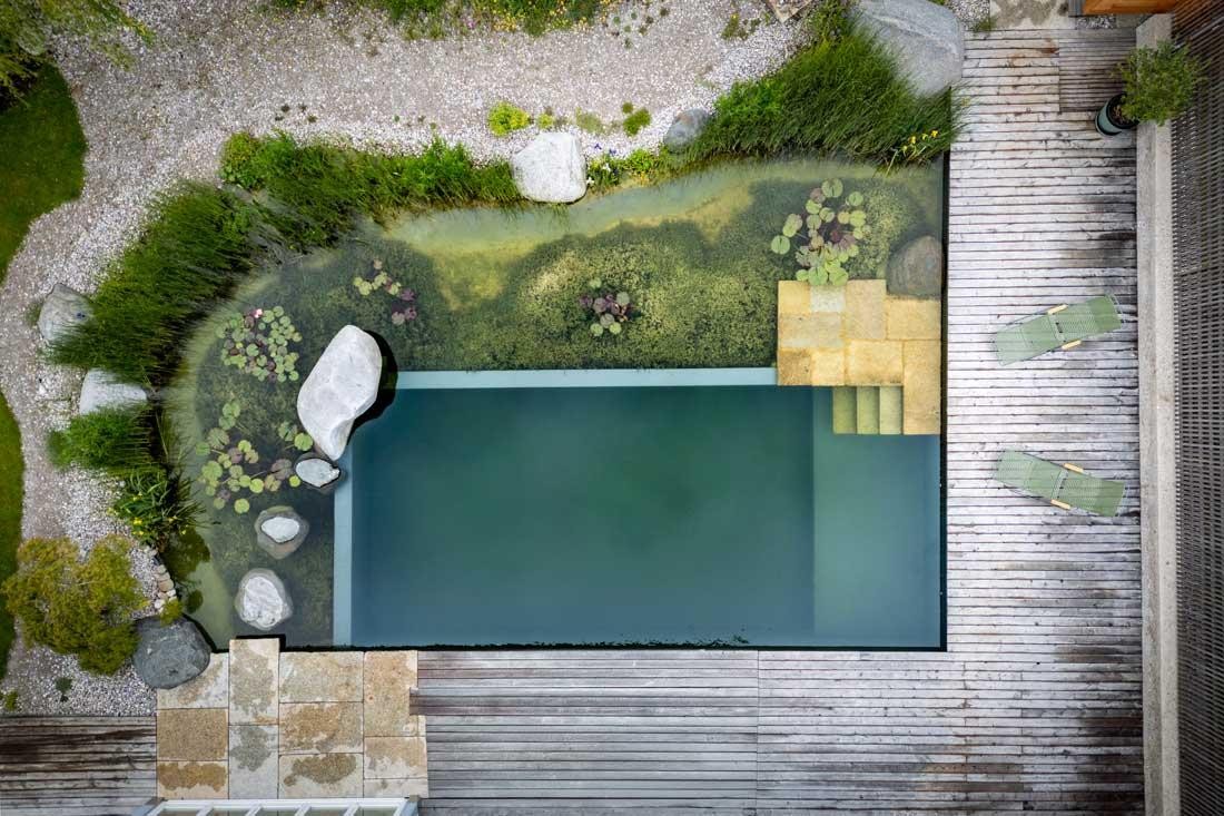 Aerial view of a natural pool with regeneration zone and wooden deck