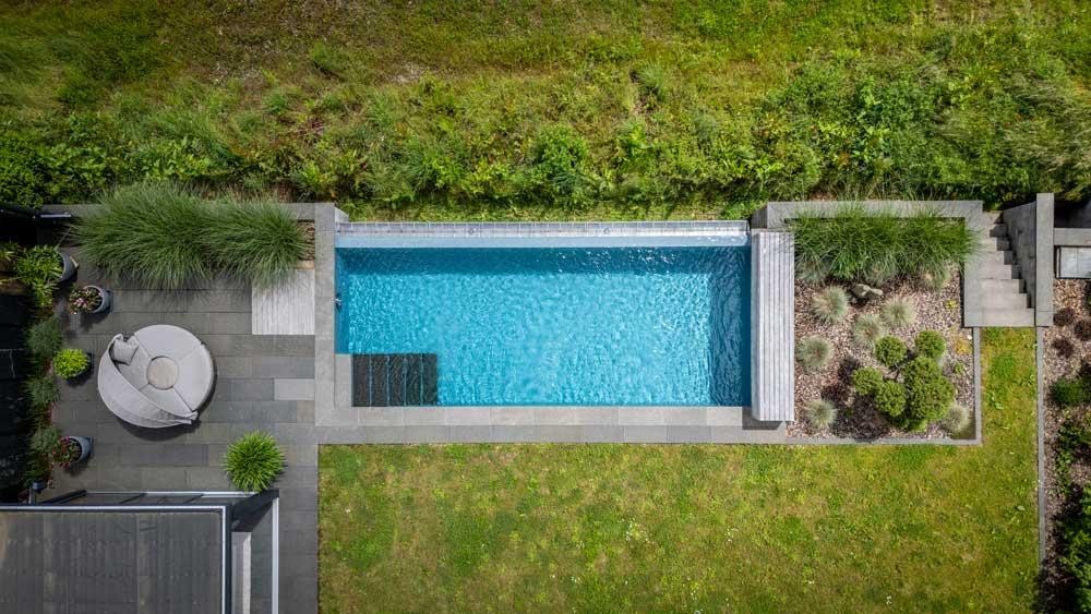 Aerial view of a natural pool in a modern sloped garden