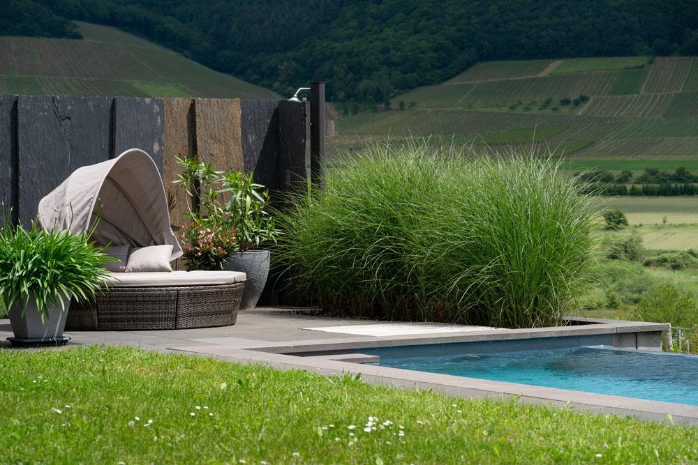 Natural pool with lounge area on a slope and wide landscape view