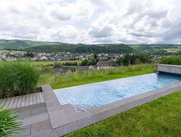 Natural pool on a slope with far-reaching views over the landscape and village