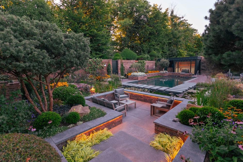 Natural pool with seating area and atmospheric garden lighting