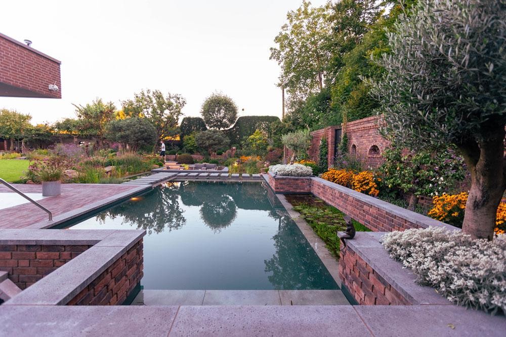 Swimming pond with brick wall flowers and clear water