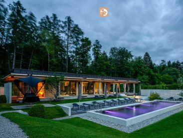 Biopool at a hotel in the evening with lighting and forest backdrop