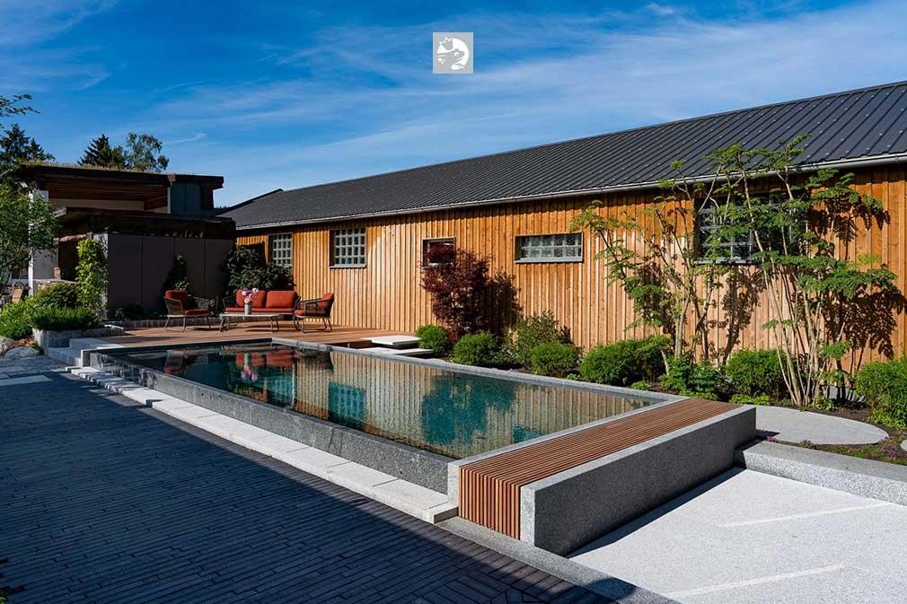 Award winning natural pool with wooden house and modern garden design
