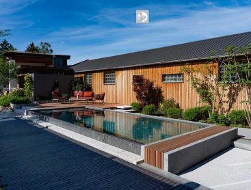Award winning natural pool with wooden house and modern garden design