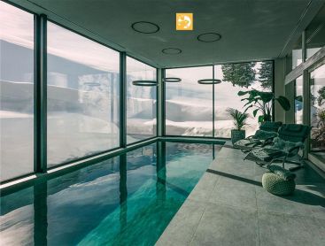 Indoor Living Pool with mountain view and loungers in wellness room