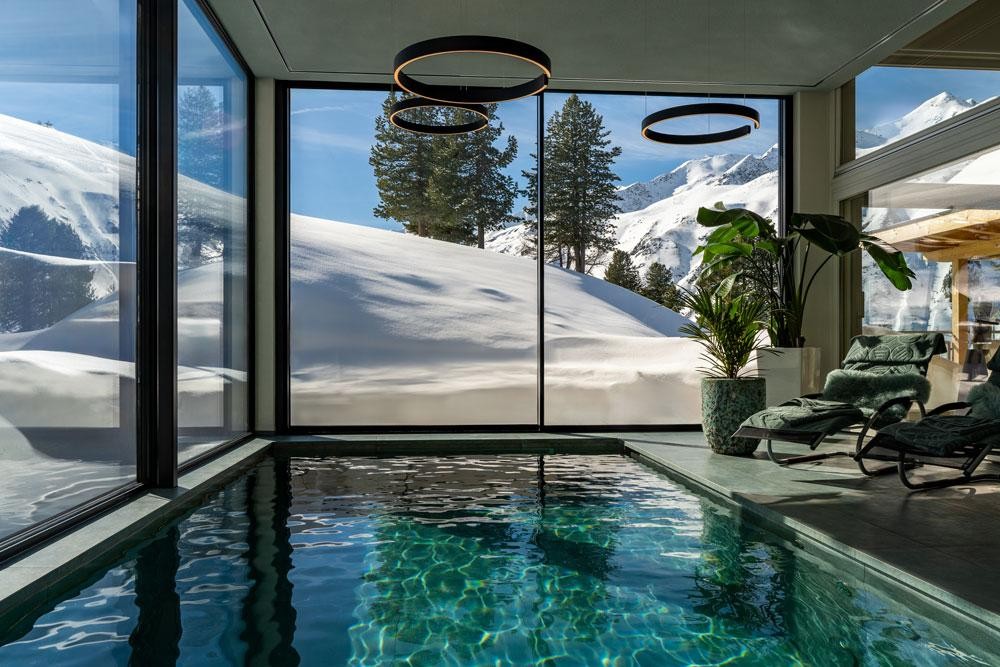 Living Pool indoors with panoramic view of snowy mountains