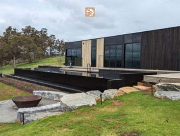 A view of the natural pool and terrace of a modern house