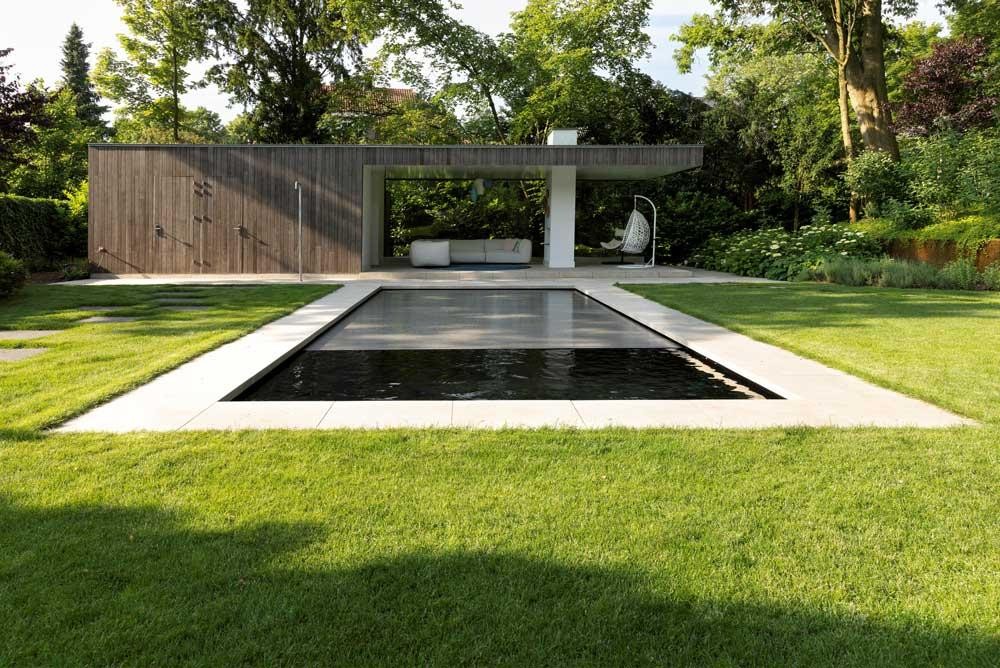 Modern natural pool with pool house and lush garden