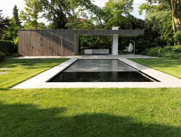 Modern natural pool with pool house and lush garden