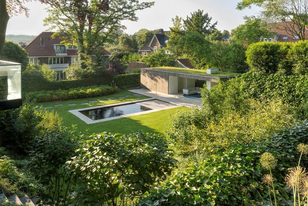 Natural pool in a spacious garden with pool house and green roof