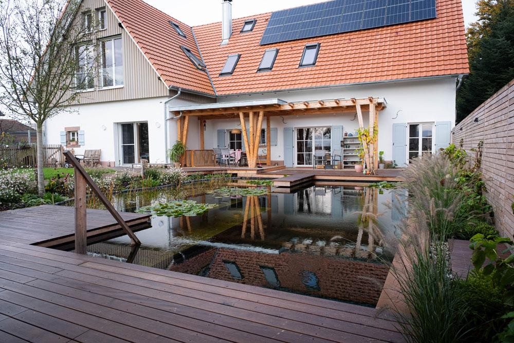 Natural pool with wood terrace modern house and solar roof
