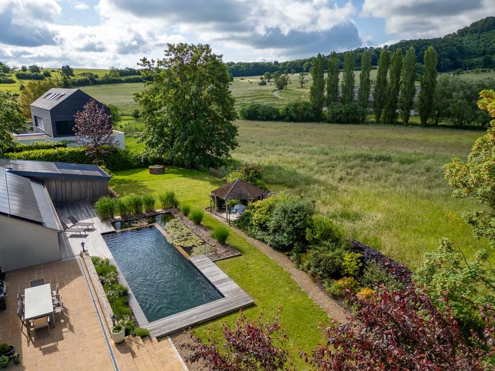 Natural swimming pond from above with wooden deck