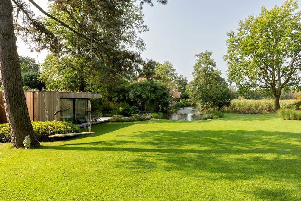 Spacious garden with a natural pool sun lawn and mature trees