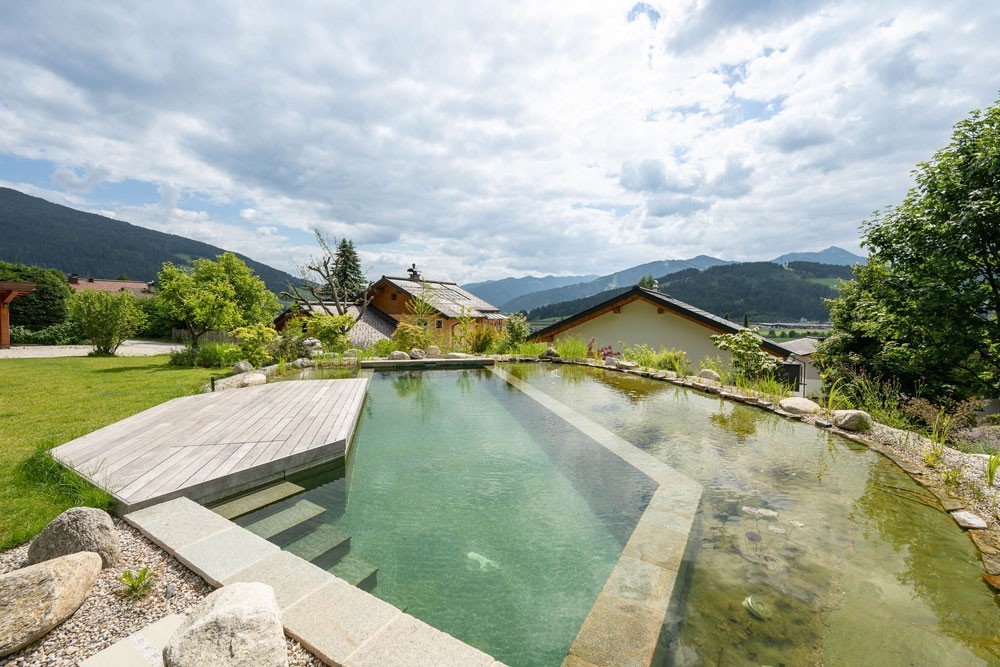 Biotop Swimming Pond in front of a natural landscape surrounded by mountains