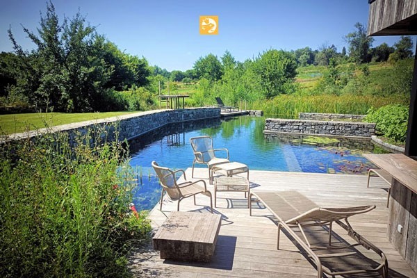 An idyllic Swimming Pond with a dreamlike wooden terrace