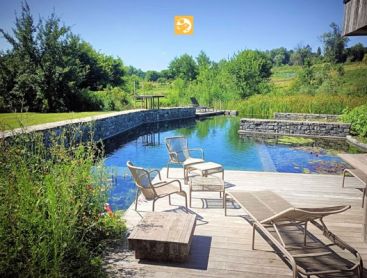 An idyllic Swimming Pond with a dreamlike wooden terrace