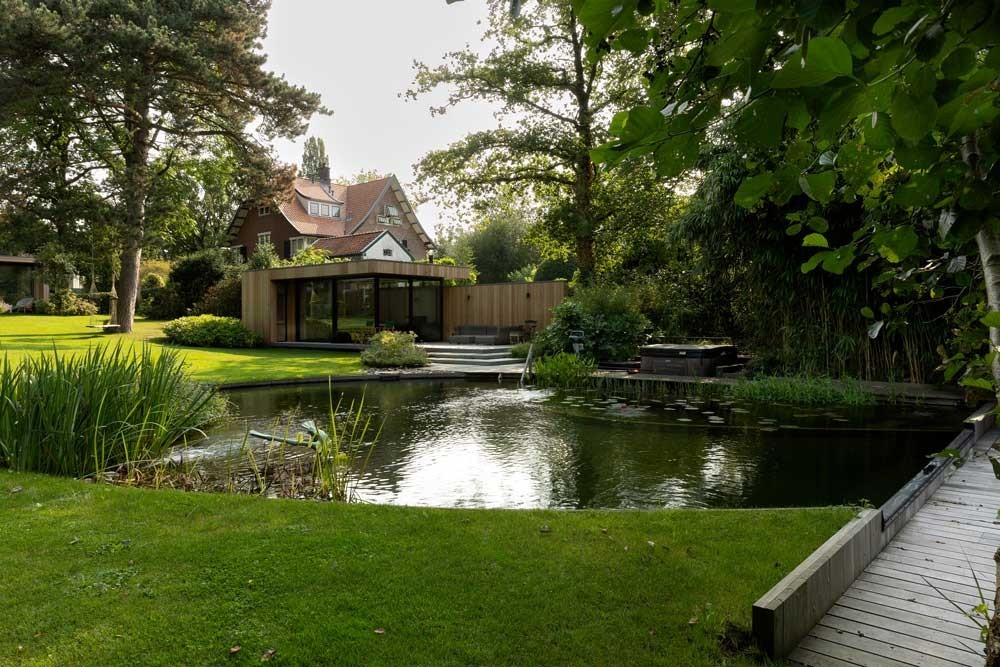 Swimming pond with wooden jetty and clear water surface in a large garden
