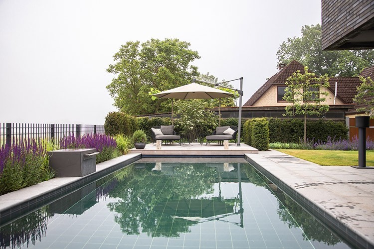 Tiled natural pool with seating on an elegant terrace