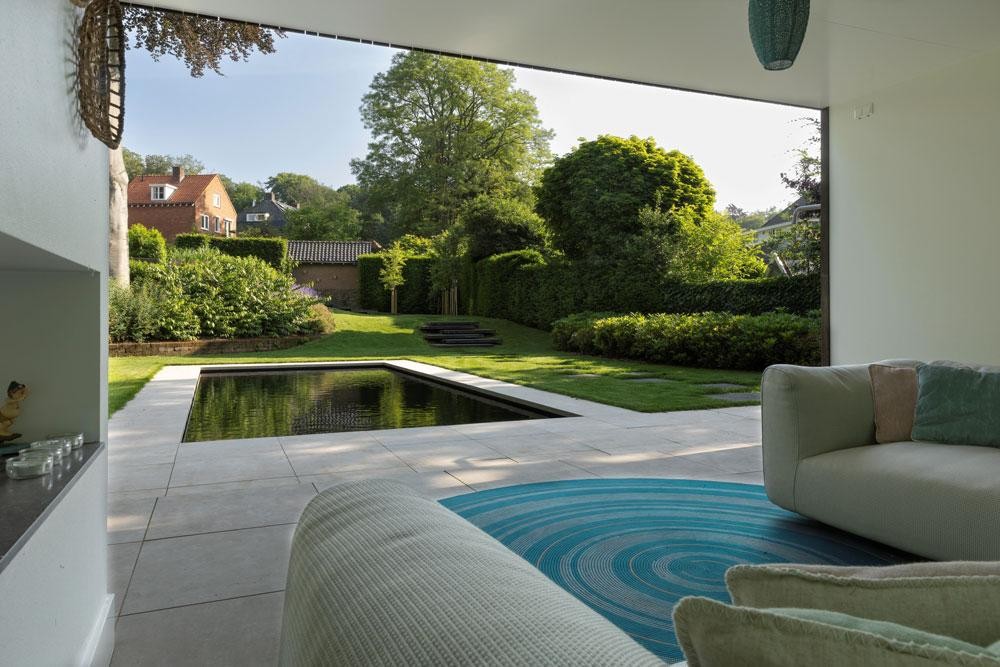View from the lounge to the natural pool, terrace and green garden
